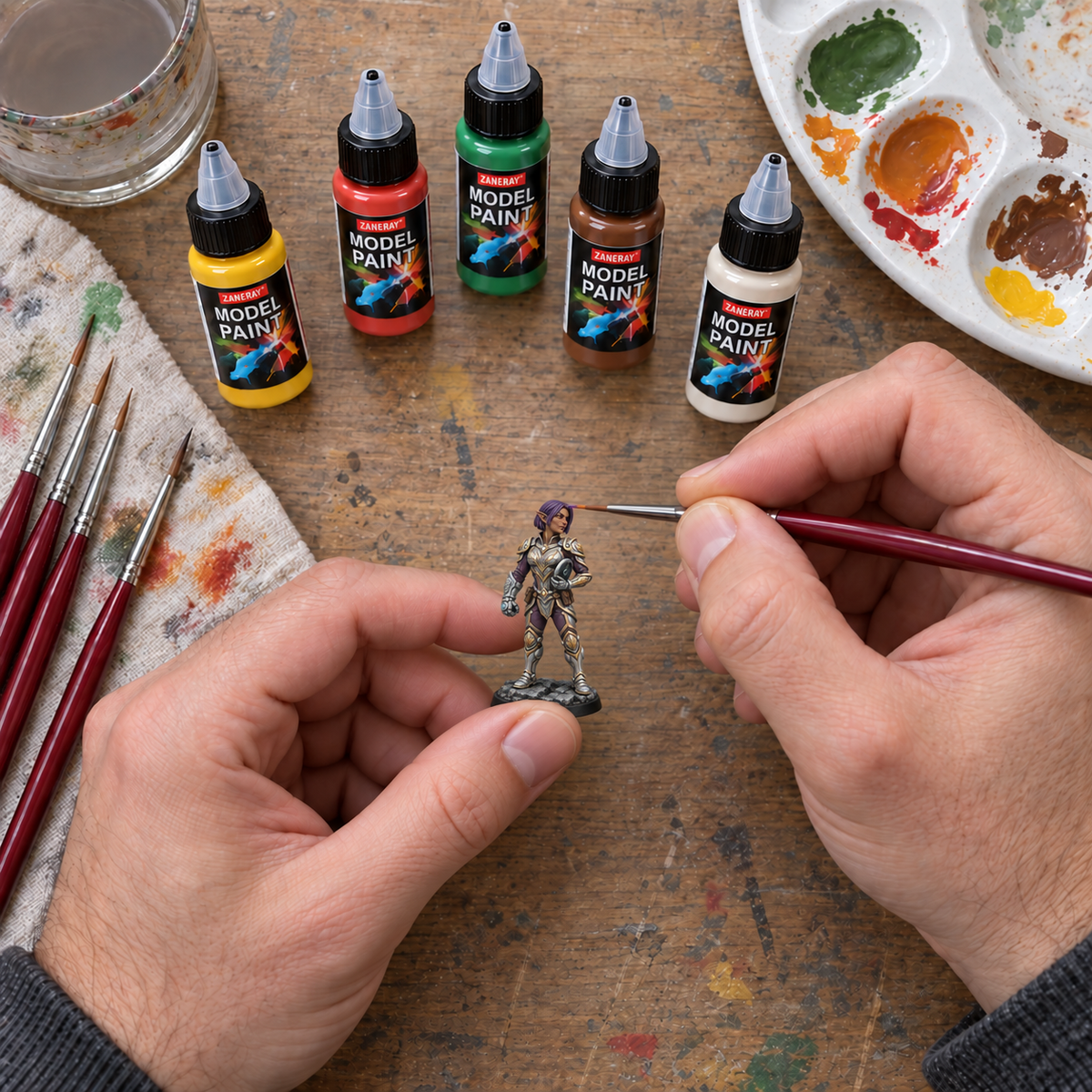 Digitally created overhead painting scene with a small Maevra miniature, acrylic paints and detail brush.
